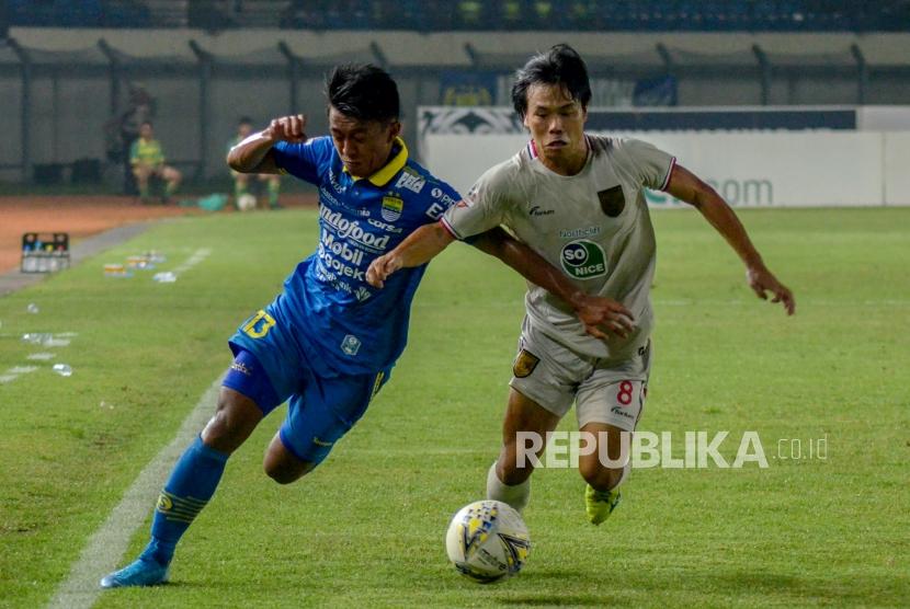 Pesepakbola Persib Bandung berebut bola dengan pesepakbola Kei Hirose (kanan).