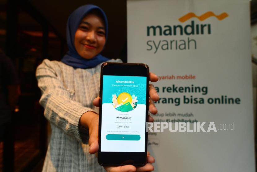 Nasabah menunjukkan fitur pembukaan rekening online melalui Mandiri Syariah Mobile di Jakarta, Kamis (5/1). Mandiri Syariah menjamin pelayanan terhadap nasabah akan tetap baik di tengah proses penggabungan bank-bank syariah anak usaha bank BUMN. 