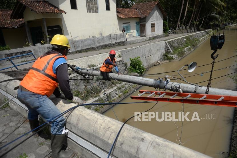 Imbas Bencana Hidrometeorologi. Petugas PLN mengevakuasi tiang listrik yang tumbang imbas bencana meteorologi di Minggir, Sleman, Yogyakarta, Senin (9/12).