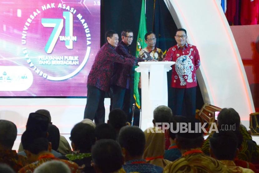 Menteri Hukum dan HAM Yasonna Laoly (kedua kiri), Menteri Koordinator bidang Politik, Hukum dan Keamanan Mahfud MD (kedua kanan) dan Gubernur Jawa Barat Ridwan Kamil (kanan) bersama-sama menekan tombol pada Peringatan Hari Hak Asasi Manusia (HAM) Sedunia ke-71 Tahun 2019, di Gedung Merdeka, Kota Bandung, Selasa (10/12).