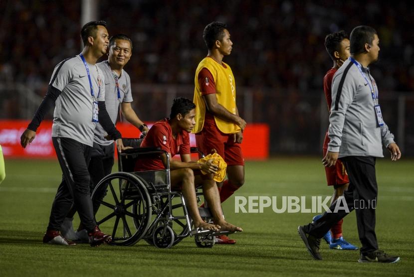 Pemain timnas Indonesia Evan Dimas didorong menggunakan kursi roda usai dikalahkan timnas Vietnam pada pertandingan final sepak bola SEA Games 2019 di Rizal Memorial Stadium, Manila, Filipina, Selasa (10/12).