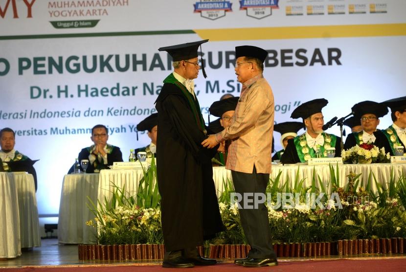 Pengukuhan Guru Besar Haedar Nashir. Prof Haedar Nashir menerima ucapan selamat dari mantan Wapres Jusuf Kalla saat upacara Pengukuhan Guru Besar di Sportorium UMY, Yogyakarta, Kamis (12/12).