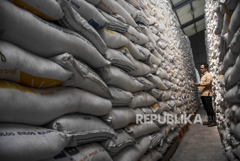 Petugas memeriksa tumpukan beras di Gudang Bulog Divre Jawa Barat di Kawasan Gedebage, Kota Bandung, Jumat (13/12).