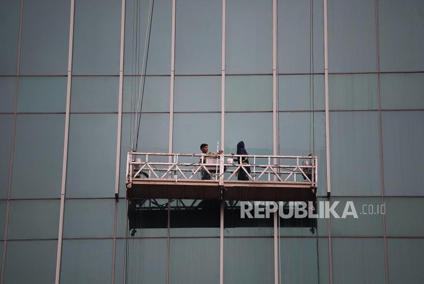 Pekerja dengan menggunakan gondola membersihkan kaca sebuah gedung bertingkat (ilustrasi). Petugas damkar menyelamatkan 2 pekerja yang tersangkut di gondola gedung UNJ.