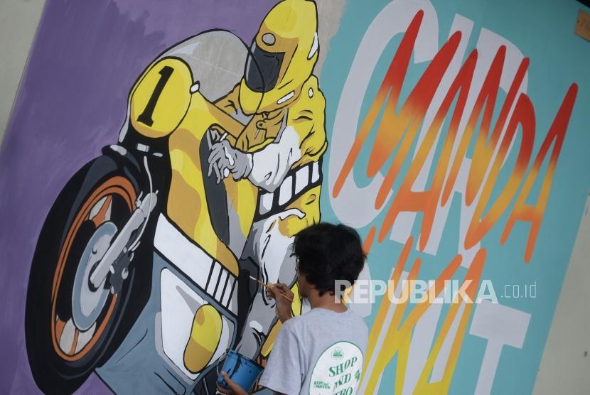 Mural Menuju Moto GP Mandalika. Seniman menggambar mural di Yogyakarta, Ahad (15/12).