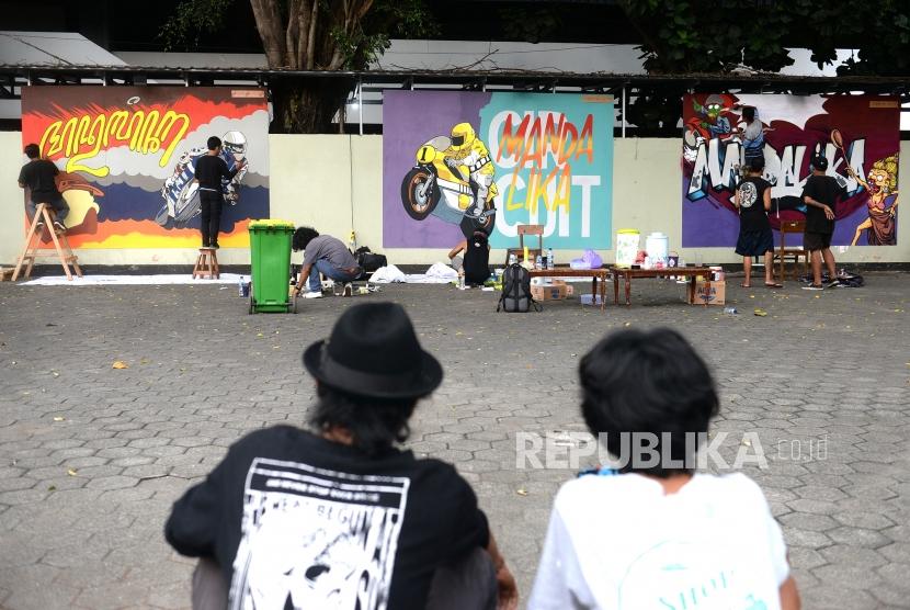 Mural Menuju Moto GP Mandalika. Seniman menggambar mural di Yogyakarta, Ahad (15/12).