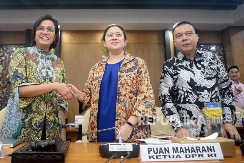 Ketua DPR Puan Maharani (tengah) berjabat tangan dengan Menteri Keuangan Sri Mulyani (kiri) didampingi Wakil Ketua DPR Sufmi Dasco Ahmad (kanan) usai rapat konsultasi Kompleks Parlemen, Senayan, Jakarta, Senin (16/12).