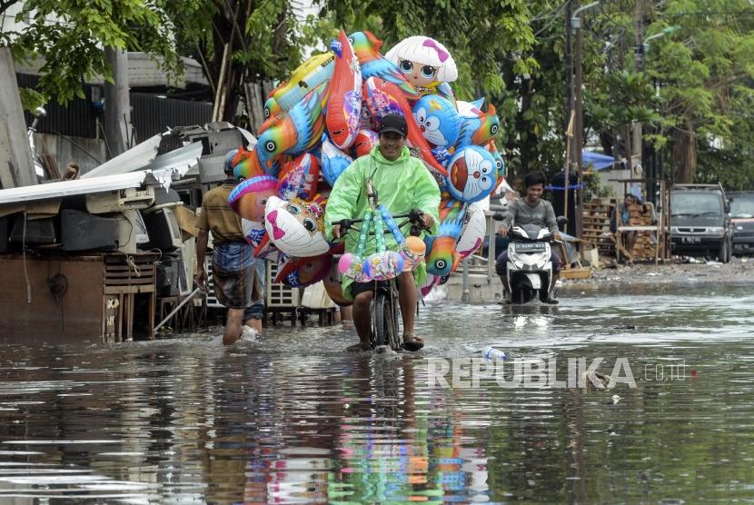 Pedagang melintas menggunakan sepeda saat terjadi banjir di kawasan Sunter, Jakarta, pekan lalu. Jakarta kembali dilanda banjir pada hari pertama tahun 2020, Rabu (1/1).