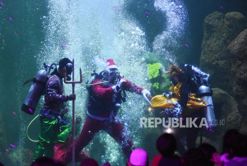 Penyelam yang mengenakan kostum Sinterklas tampil pada pertunjukan di dalam air di Seaworld, Ancol, Jakarta, Rabu (25/12/2019).