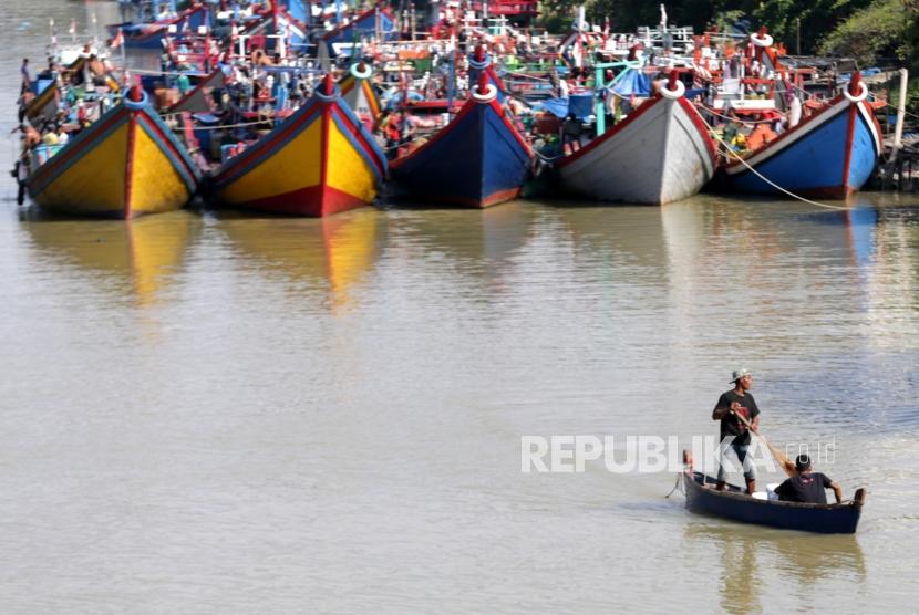 Warga berada di atas perahu dengan latar belakang kapal dan perahu nelayan yang ditambatkan di Daerah Aliran Sungai (DAS) Krueng Aceh, Peunayong, Banda Aceh, Aceh, Rabu (25/12/2019).