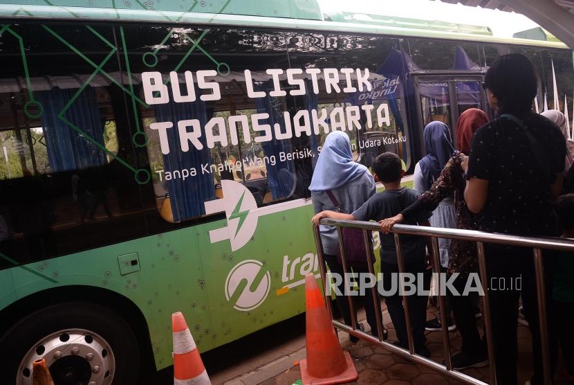 Warga bersiap menaiki bus listrik di Kawasan Monas, Jakarta, Kamis (26/12).