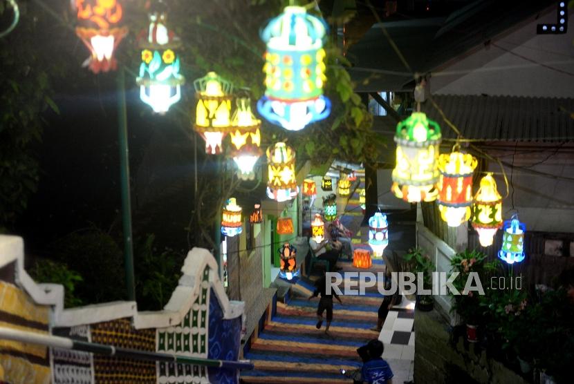  Sebanyak 10 ribu lampion akan menyala terang dengan beraneka warna-warni setiap malam di Sekolah Maitreyawira Palembang.  Foto: Aneka bentuk lampion dipasang warga di Kampung Lampion Code 18, Yogyakarta, Sabtu (28/12) malam. 
