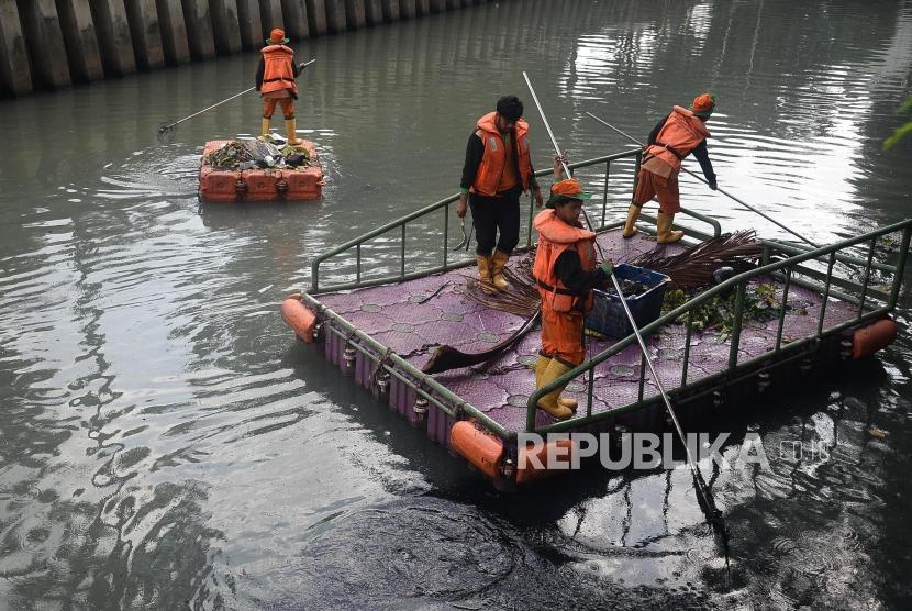 Petugas UPK Badan Air Dinas Lingkungan Hidup DKI Jakarta membersihkan sampah di Kali Cideng, Jakarta, Senin (30/12).