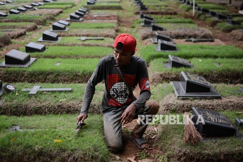 Penjaga makam beraktifitas di Tempat Pemakaman Umum (TPU) Pondok Ranggon, Cipayung, Jakarta, Minggu (30/12).