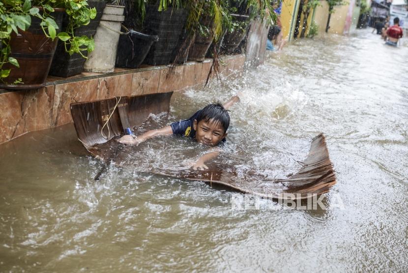 Anak-anak bermain saat terjadi banjir di kawasan Jatipadang, Pasar Minggu, Jakarta, Rabu (1/1). Sebagian wilayah Jakarta banjir termasuk di Bandara Halim Perdana Kusuma.
