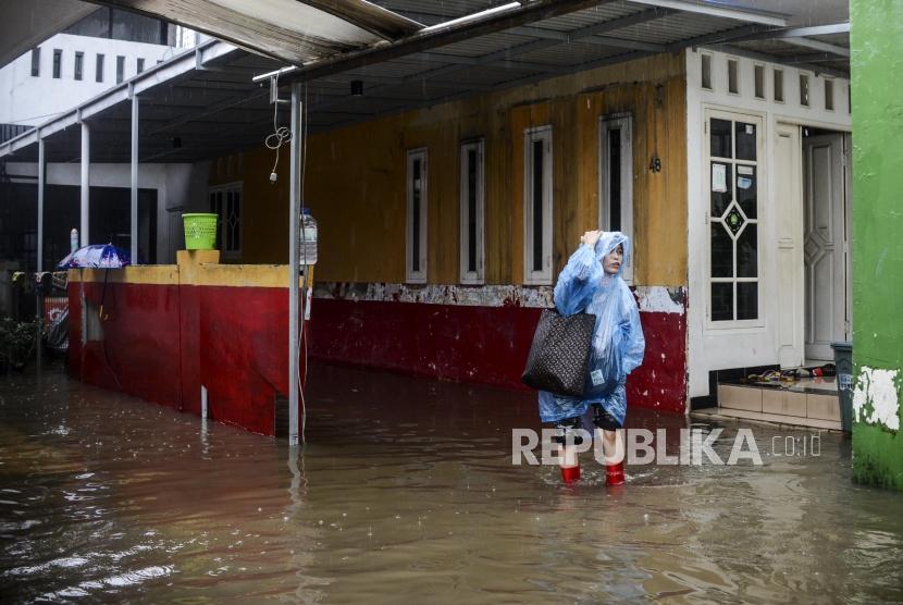 Seorang warga meninggalkan rumahnya saat terjadi banjir di kawasan Jatipadang, Pasar Minggu, Jakarta, Rabu (1/1).