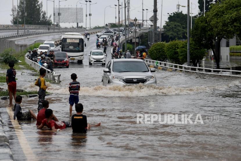 Kendaraan melintasi genangan banjir yang merendam jalan S.Parman, Grogol, Jakarta, Rabu (1/1).