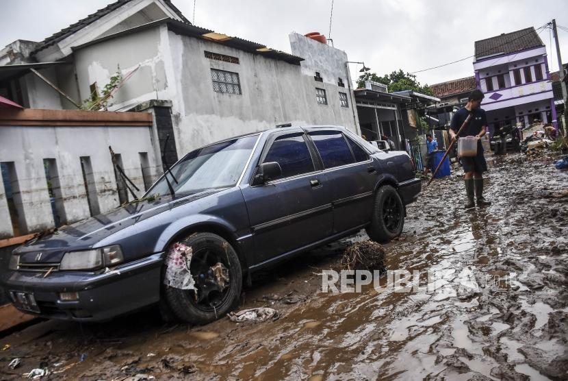 Warga membersihkan lumpur sisa banjir di Komplek Perumahan Cimareme Indah, Desa Cimareme, Kecamatan Ngamprah, Kabupaten Bandung Barat, Rabu (1/1).
