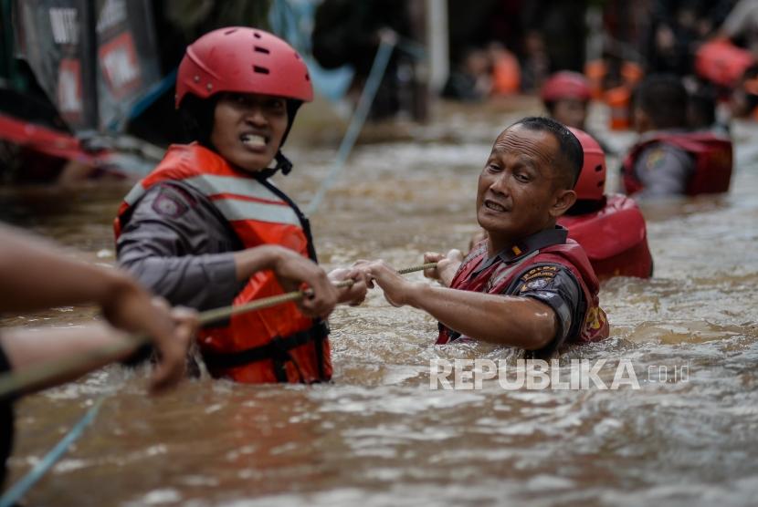 Polda Metro Jaya Pastikan Personel Cukup Bantu Korban Banjir. Petugas Kepolisian mengevakuasi korban banjir di Kampung Bayur, Cipinang Melayu, Jakarta Timur.