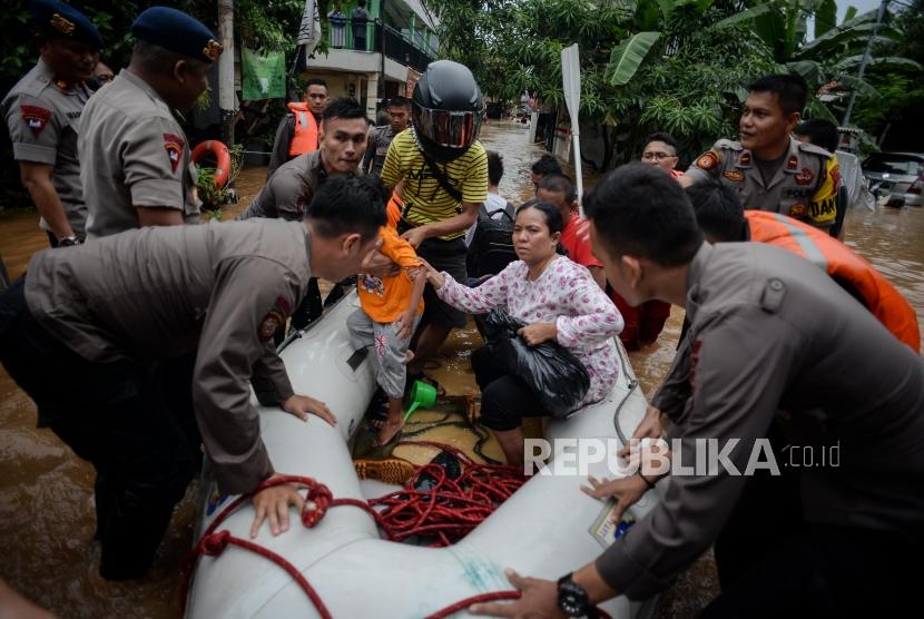 Petugas Kepolisian mengevakuasi korban banjir di Kampung Bayur, Cipinang Melayu, Jakarta Timur, Rabu (1/1).