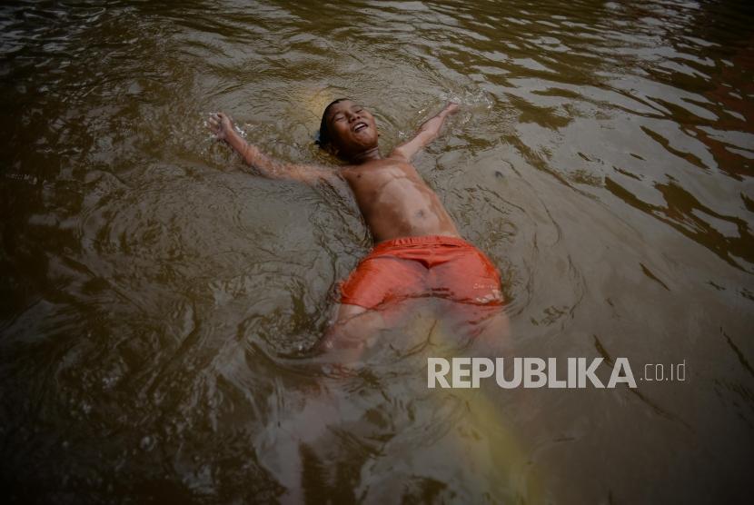 Sejumlah anak bermain saat banjir di Gang Hj Agus, Jatipadang, Jakarta, Rabu (1/1). Kawasan Pejaten dekat Jatipadang juga terserang banjir di awal tahun baru.