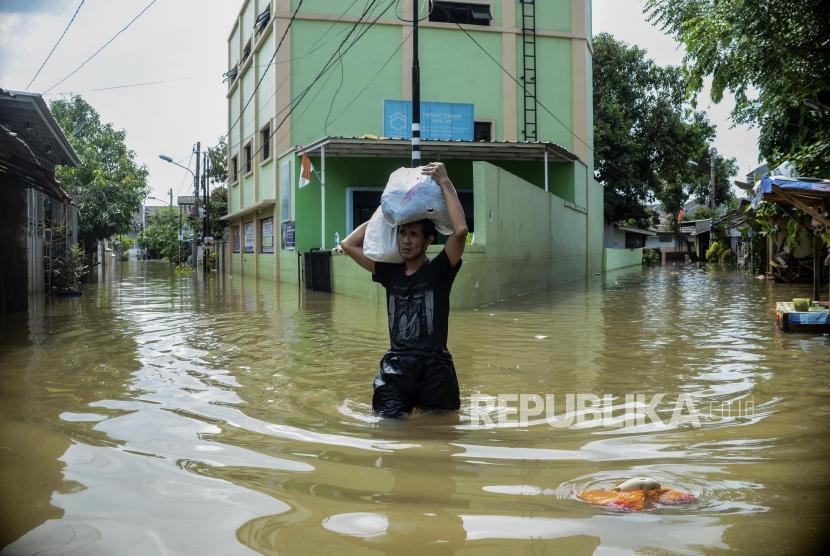 Seorang warga menyelamatkan barang saat terjadi banjir di Perumahan Ciledug Indah, Tangerang, Banten Kamis (2/1).