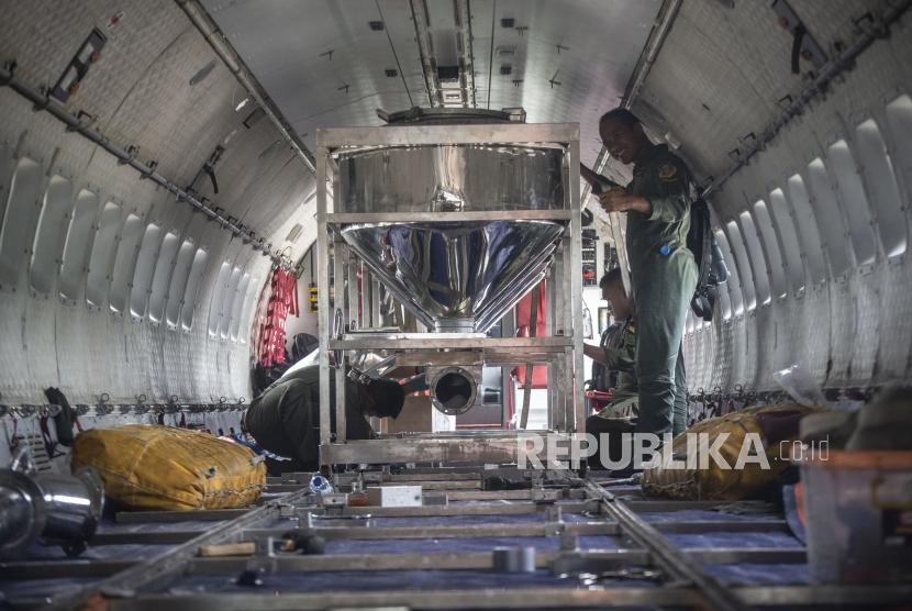 Sejumlah personel TNI AU memasang penampung garam atau consul pada Pesawat CN 295 dalam Operasi Teknologi Modifikasi Cuaca (TMC) di  Skadron Udara 2 Lanud Halim Perdanakusuma, Jakarta, Jumat (3/1/2020).