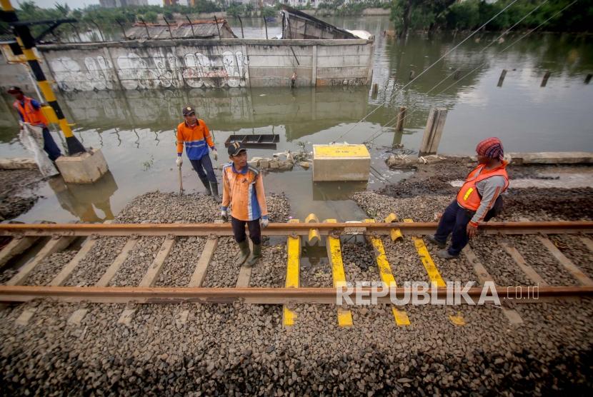 Pekerja memperbaiki rel pascabanjir di kawasan Stasiun Rawa Buaya, Jakarta, Jumat (3/1/2020). PT KAI (Persero) memastikan jalur rel kereta api aman dilalui mengingat pemeriksaan rutin terus dilakukan setiap saat dan setiap hari ketika curah hujan tinggi belakangan ini. 
