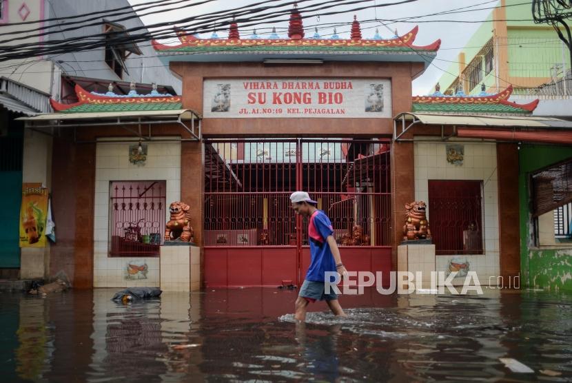 Indosat Ooredoo menyediakan bantuan pengobatan gratis dan fasilitas komunikasi gratis bagi korban banjir. Foto sejumlah warga melawati genangan air banjir di Jalan Teluk Gong, Penjaringan, Jakarta Utara, (ilustrasi).