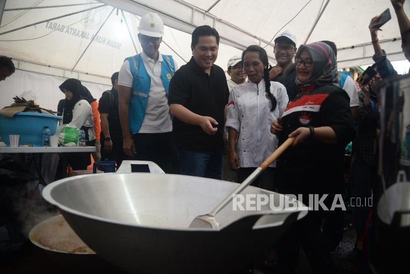 Menteri BUMN Erick Thohir berbincang dengan juru masak ketika meninjau dapur umum di Kantor Kecamatan Cengkareng,Jakarta, Ahad (5/1).