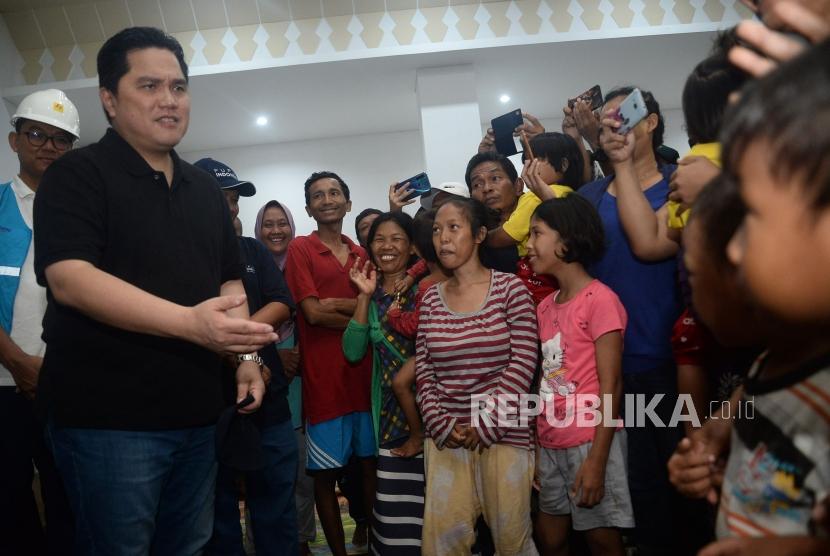 Menteri BUMN Erick Thohir bercengkrama dengan para pengungsi korban banjir di posko pengungsian GOR Cengkareng,Jakarta, Ahad (5/1).