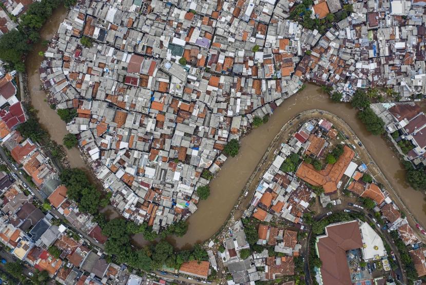Foto udara suasana wilayah bantaran sungai Ciliwung yang belum dinormalisasi (atas) dan yang sudah dinormalisasi (bawah kanan) di kawasan Bukit Duri, Jakarta, Minggu (5/1/2020).