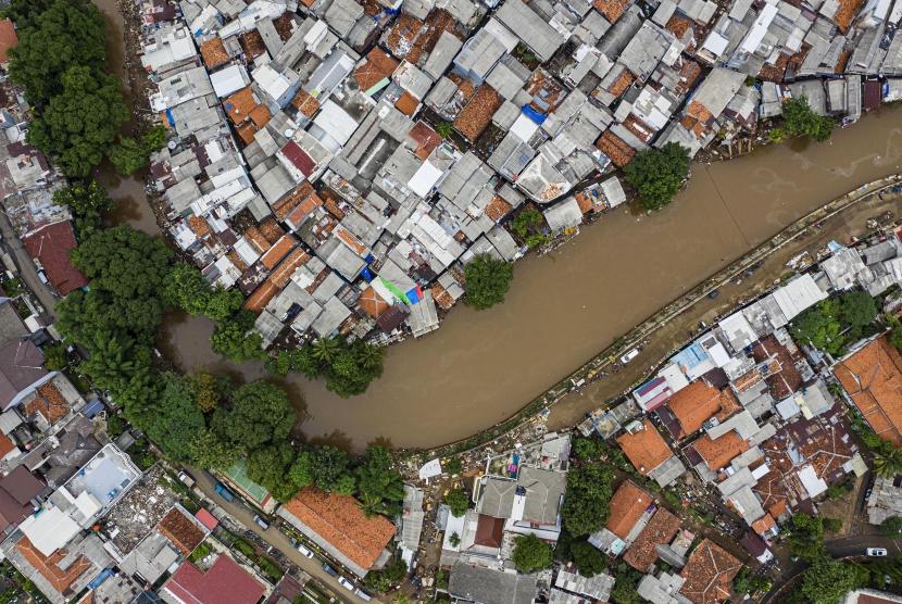Foto udara suasana wilayah bantaran sungai Ciliwung yang belum dinormalisasi (atas) dan yang sudah dinormalisasi (bawah kanan) di kawasan Bukit Duri, Jakarta, Minggu (5/1/2020).