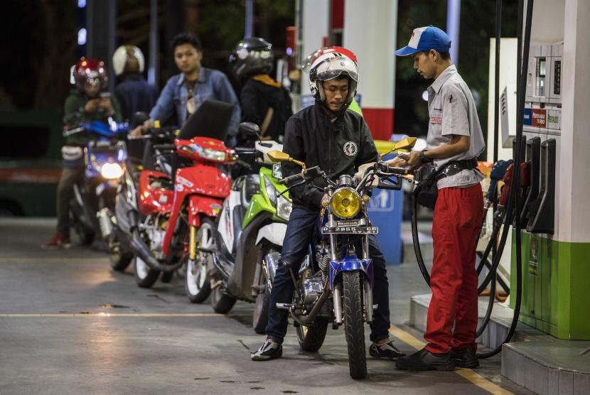 Operator SPBU melakukan pengisian bahan bakar minyak (BBM) ke kendaraan konsumen di SPBU Dago, Bandung, Jawa Barat, Minggu (5/1). PT Pertamina menyebutkan terjadi penudunan konsumsi BBM hingga 40 persen di Kota Bandung.