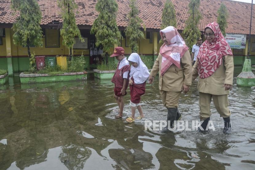 Sejumlah guru dan murid SDN 05 beraktivitas saat banjir di daerah Pondok Ungu, Kabupaten Bekasi, Jawa Barat, Senin (6/1/2020).