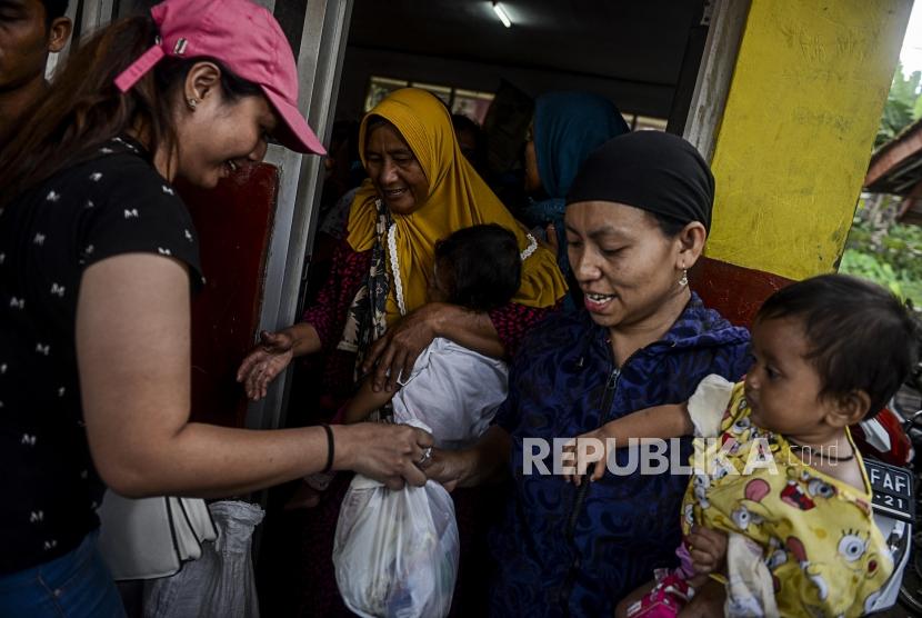 Sejumlah warga menerima bantuan sembako di Desa Harkatjaya, Sukajaya, Bogor, Jawa Barat, Senin (6/1).