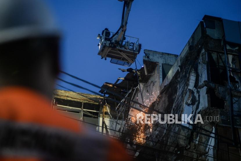 Tim evakuasi memotong bagian beton yang rubuh di Jalan Brigjen Katamso, Slipi, Jakarta Barat, Senin (6/1).
