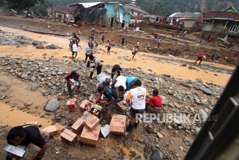 Sejumlah warga mengambil bantuan logistik yang dijaruhkan melalui helikopter di Kampung Muhara, Lebak Gedong, Lebak, Banten, Senin (6/1). (ilustrasi)