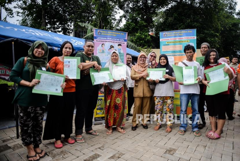 Sejumlah warga terdampak banjir memperlihatkan dokumen kependudukan pengganti kepada para korban banjir di posko Pengadegan, GOR Pancoran, Jalan Pengadegan, Pancoran, Jakarta Selatan, Selasa (7/1).