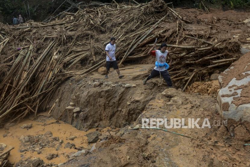 Sejumlah warga melintasi longsor di Kampung Banar, Sukajaya, Bogor, Jawa Barat. Perubahan iklim membawa pengaruh hingga 30 persen terhadap peningkatan bencana
