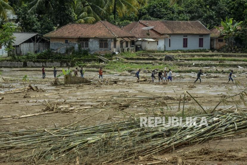 Sejumlah warga melintasi lumpur akibat longsor di Kampung Banar, Sukajaya, Bogor, Jawa Barat, Selasa (7/1).