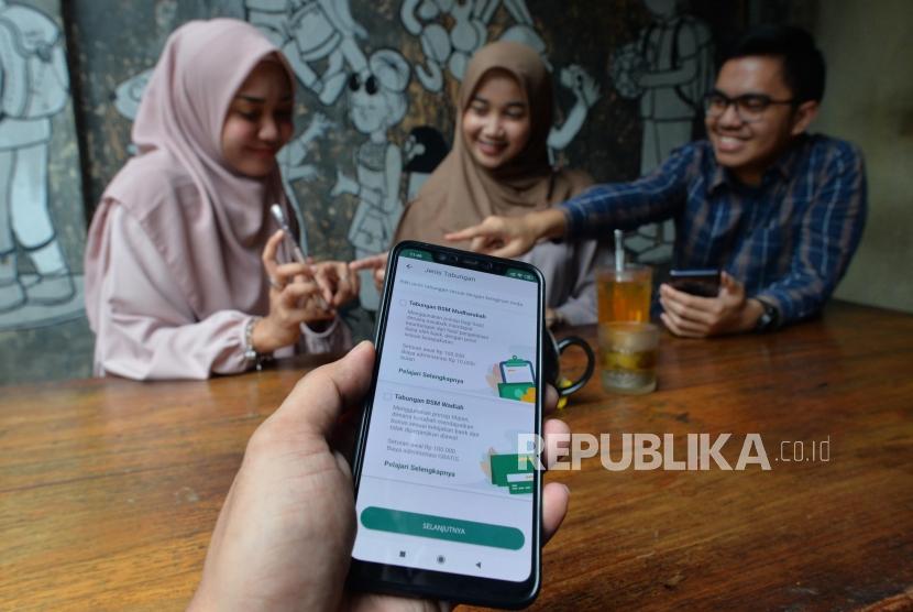 Sejumlah anak muda tengah membuka rekening Mandiri Syariah melalui aplikasi Mandiri Syariah Mobile di salah satu kafe di Jakarta, Rabu (8/1).