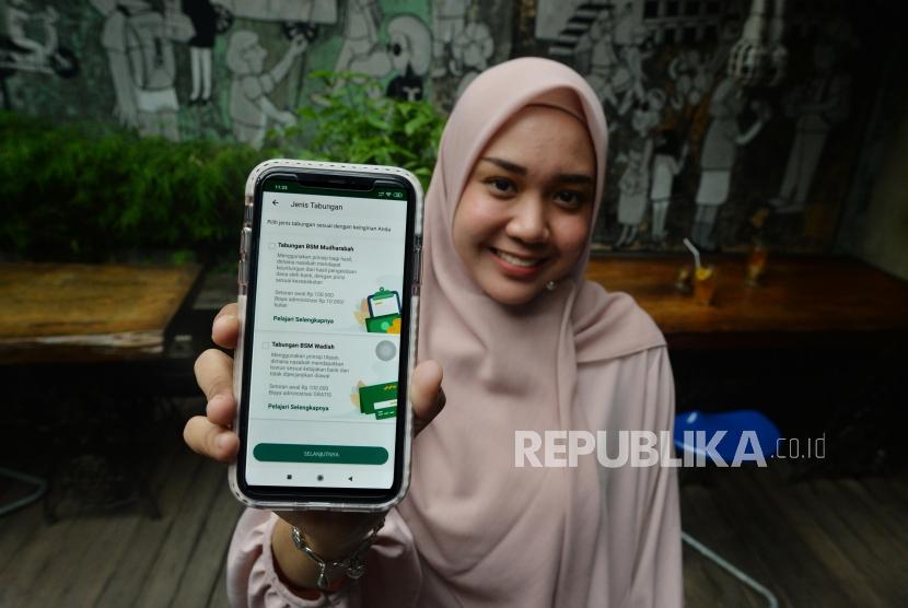Seorang anak muda menunjukkan aplikasi Mandiri Syariah mobile di telepon genggamnya di salah satu kafe di Jakarta, Rabu (8/1).
