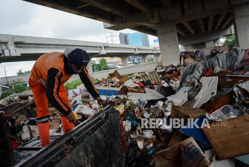 Petugas PPSU menampung sampah di kolong Tol Becakayu yang hanyut akibat banjir dikawasan Cipinang Melayu, Jakarta Timur, Kamis (2/9).