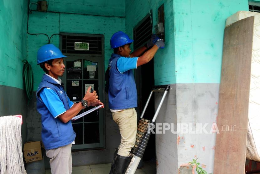 Petugas PLN memasang instalasi listrik baru di rumah yang menjadi korban banjir di Perumahan Pondok Gede Permai Bekasi, Jumat (10/1).