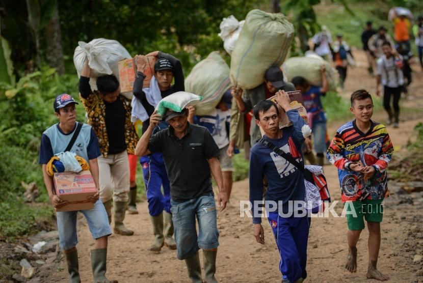 Warga korban longsor dan banjir bandang mengangkut bantuan yang di berikan organisasi kemanusiaan Aksi Cepat Tanggap (ACT) di Desa Lebak Situ, Kecamatan Lebak Gedong, Banten, Minggu (12/1).