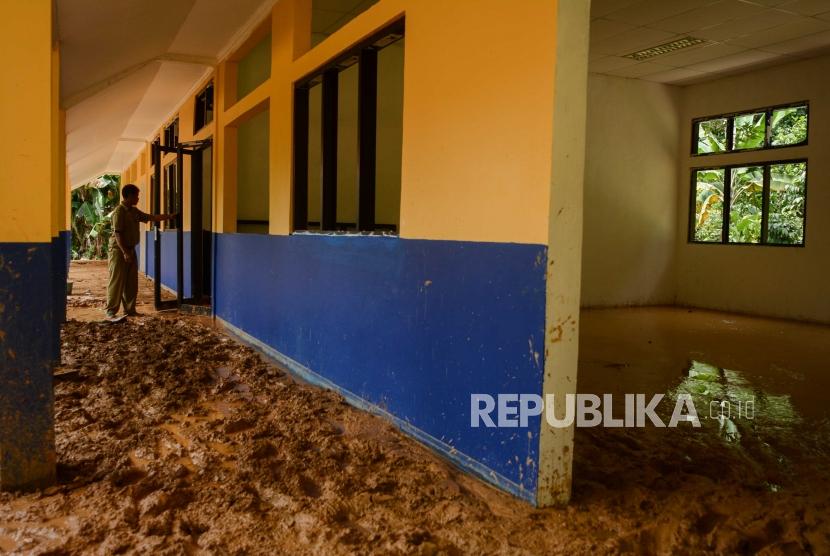 Guru Sekolah Dasar Negeri 1 Lebaksitu meliihat kondisi sekolah terdampak longsor di Kampung Gunung Julang, Desa Lebaksitu, Kecamatan Lebak Gedong, Banten, Senin (13/1).