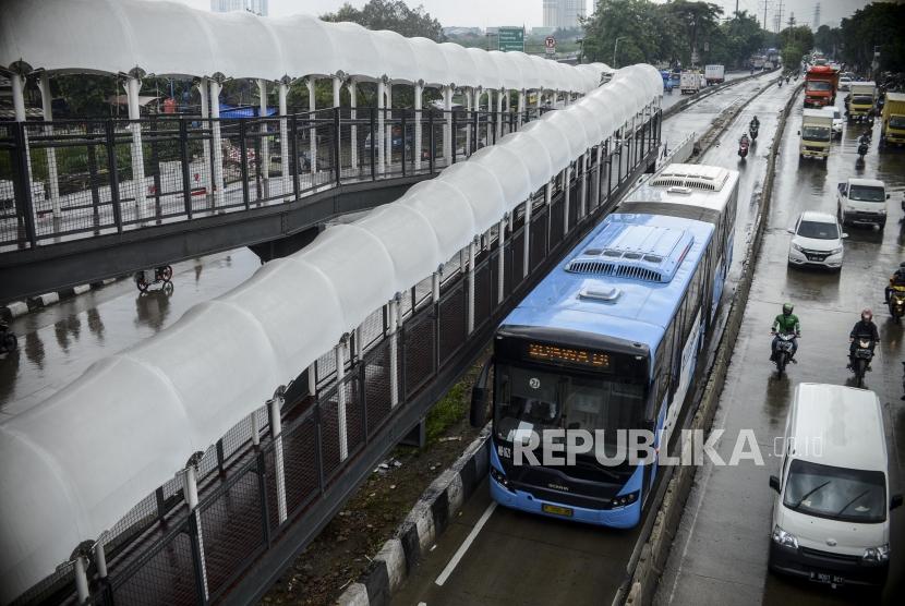 Bus Transjakarta melintas di dekat jembatan penyeberangan orang (JPO) Jembatan Gantung di Jalan Daan Mogot, Cengkareng, Jakarta, Senin (13/1).(Republika/Putra M. Akbar)
