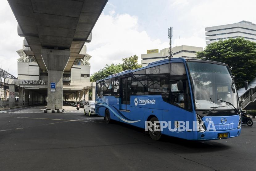 Bus Transjakarta melintas di dekat Stasiun MRT ASEAN di Jakarta, Selasa (14/1).