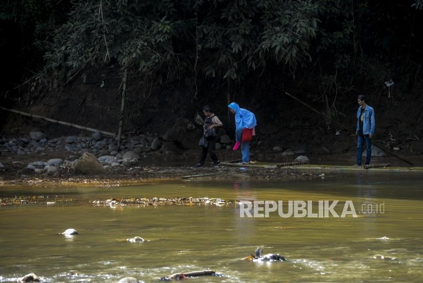 Warga turun dari eretan yang terbuat dari bambu untuk melewati Sungai Cikaniki di Rumpin, Bogor, Jawa Barat, Kamis (16/1).